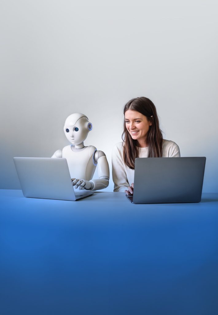 Robô humanoide e uma mulher a trabalhar lado a lado em portáteis